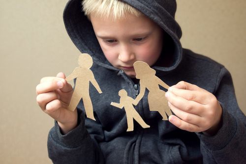 child holding up paper cutout of family
