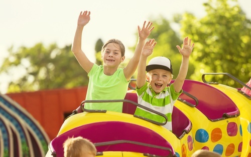 dos niños en una montaña rusa infantil