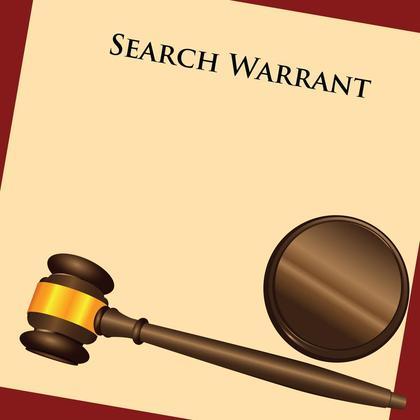 Judge's gavel placed on top of a search warrant