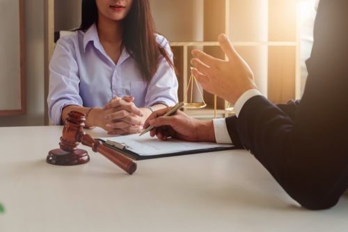 client seated at table speaking with attorney - attorney/client preparation is an important component of workers' compensation trials in California