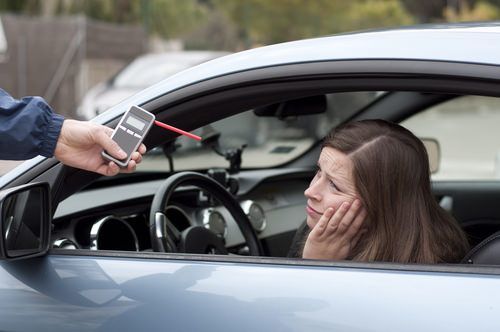 Una chica triste mirando un dispositivo de prueba de alcoholemia
