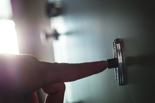 A police officer ringing the doorbell of a home or apartment