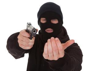 Un hombre con máscara con un arma sosteniendo a alguien en violación de NRS 200.380.