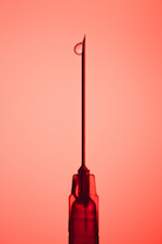 heroin needle against pink background