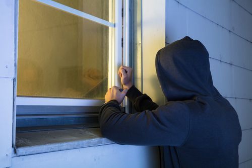 burglar breaking and entering through a window