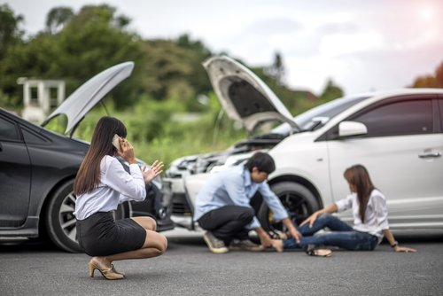 tres jóvenes después de un accidente automovilístico, con uno en el suelo herido - La cobertura de Med-pay en Nevada cubre las propias lesiones sufridas en un accidente