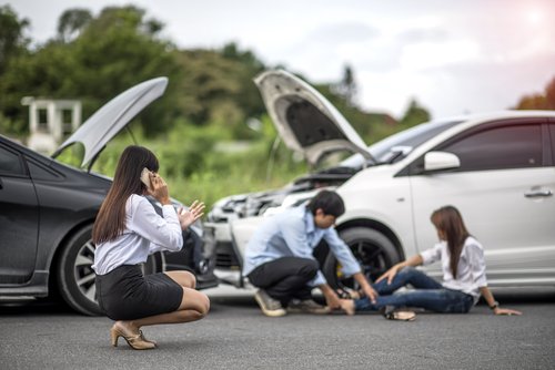 tres jóvenes después de un accidente de coche, con uno en el suelo herido - La cobertura de Med-pay en Nevada cubre las lesiones propias sufridas en un accidente