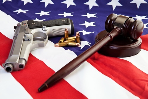 handgun and judge's gavel lying on an American flag