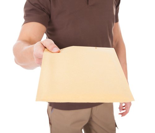 hombre con la mano extendida entregando un sobre manila como ejemplo de servicio de una citación con orden de comparecencia en California