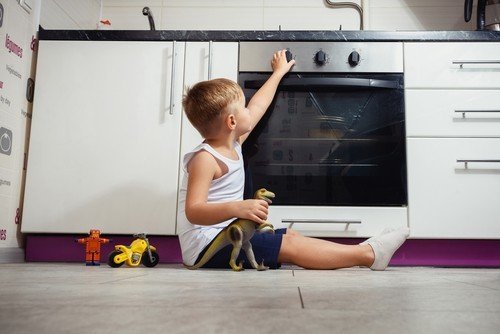 Niño tocando un horno caliente después de que su padre lo deja solo en una situación peligrosa en violación de NRS 200.508