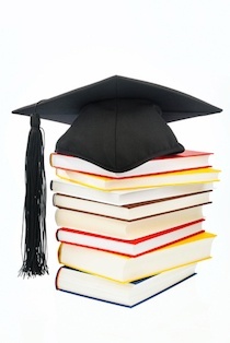 Stack of books with a graduation cap on top