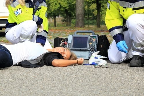 víctima de accidente siendo atendida por paramédicos - el seguro de responsabilidad por lesiones corporales en California protege a las víctimas de accidentes