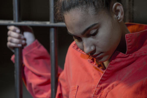 una mujer joven en una celda de la cárcel