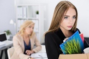 Fired employee with box packing out of the office