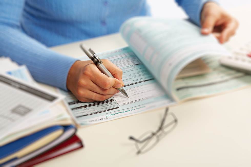 accountant writing on printed records with a pen