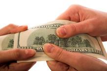 manos masculinas y femeninas sosteniendo un billete de cien dólares