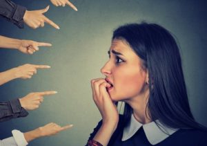 Worried looking woman with six hands pointing accusatory fingers at her