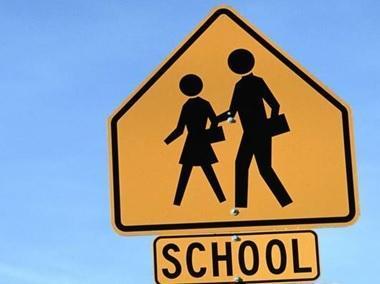 road sign saying "school" with image of two children