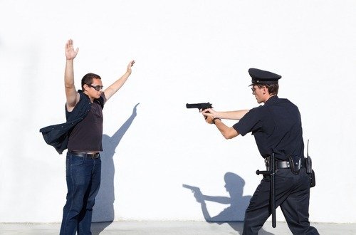 Cop aiming gun at suspect