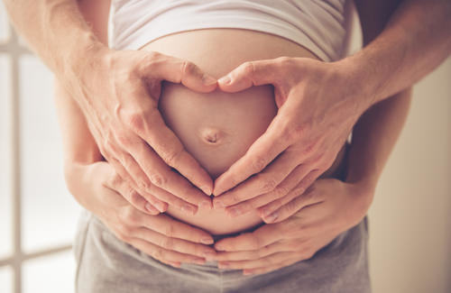 padres de nacimiento incorrecto sosteniendo vientre embarazado