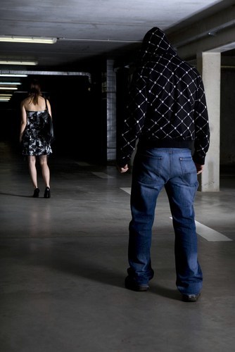 hombre acechando a una mujer vestida en un garaje