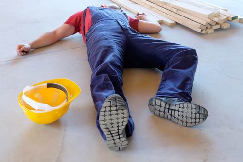 Construction worker laying on the ground after an injury - construction site accidents can give rise to personal injury claims