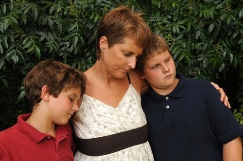 una mujer que sufre con sus dos hijos jóvenes - las familias de las víctimas de asesinato pueden presentar una demanda por muerte injusta en un tribunal civil