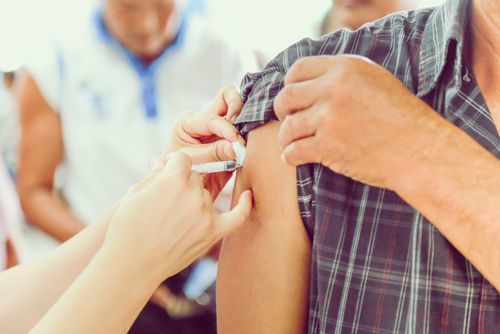 nurse giving patient a shot upper arm