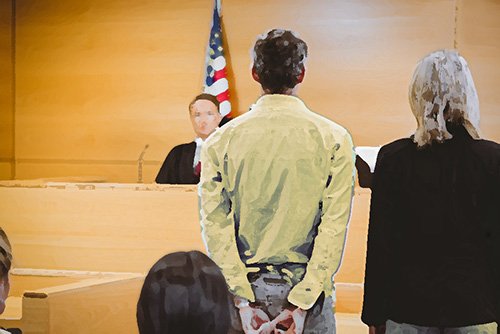 acusado con abogado de pie ante el juez en una sala de audiencias