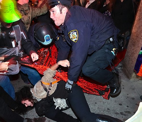 police holding down a protester