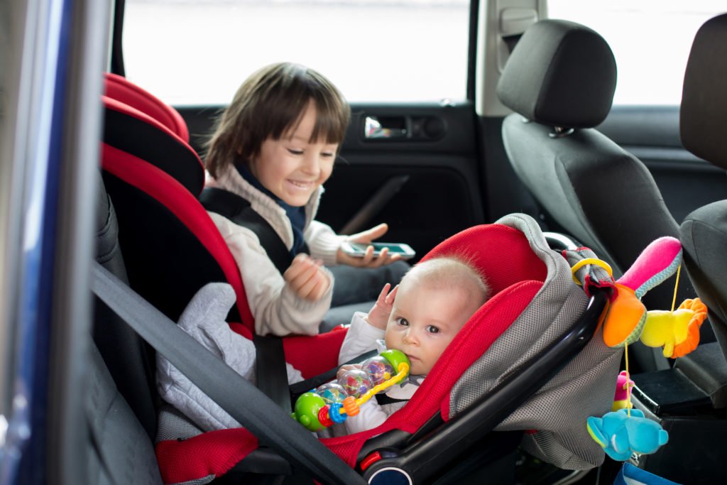 Niño y bebé en restricciones de automóvil en cumplimiento con NRS 484B.157.