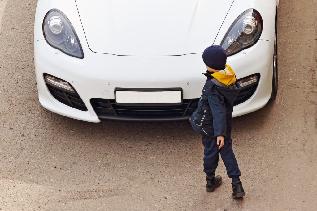 Absent-minded child in front of a car trying to aovid him. 