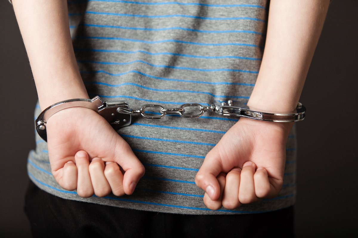 A minor in handcuffs - a conviction for Penal Code 303a PC can lead to up to 6 months in jail