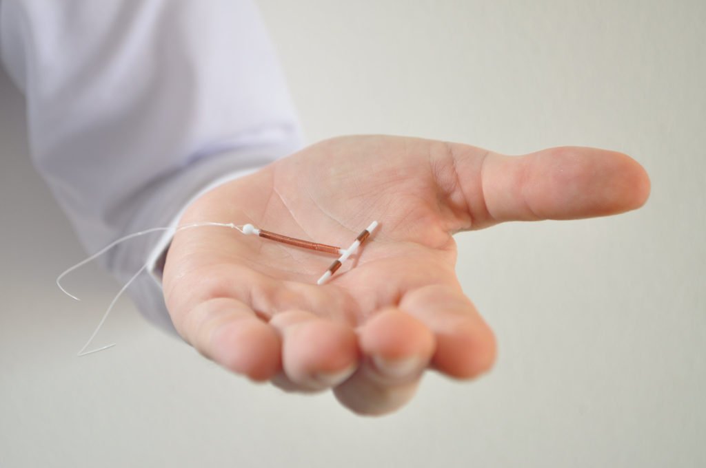 Doctor holding copper IUD.