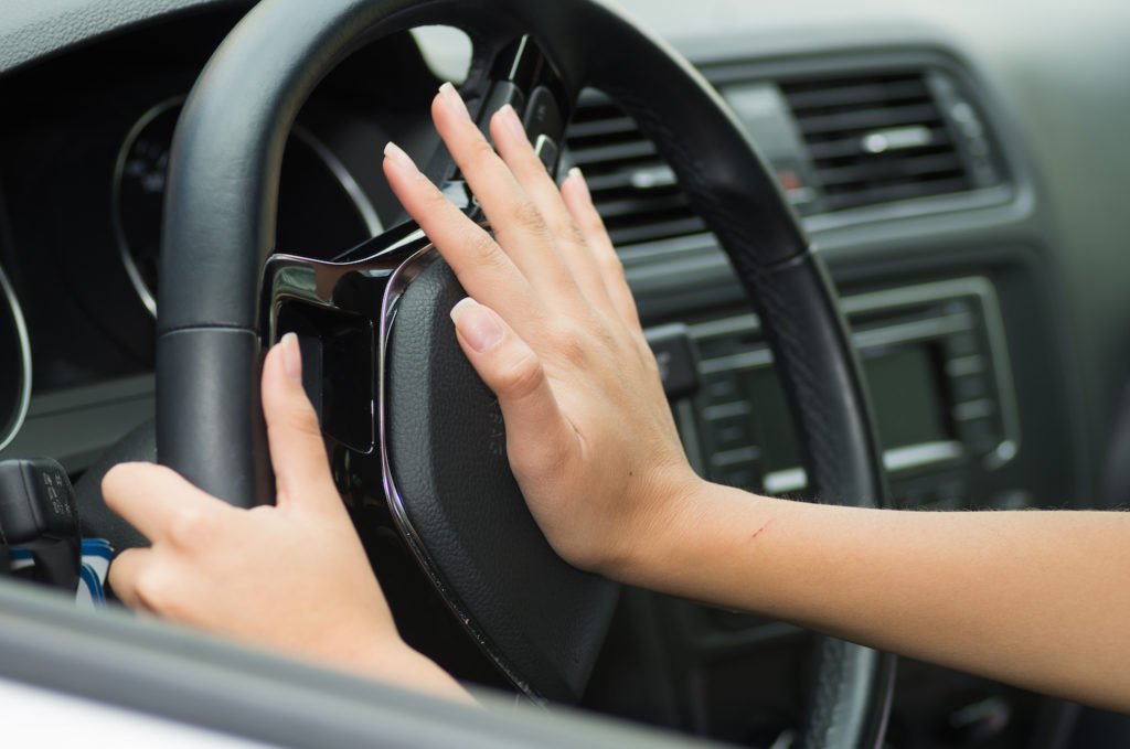 Woman honking the horn at a pedestrian in accordance with CRS 42-4-807.