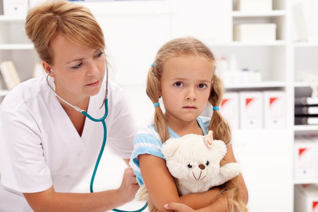 Médica - quien es reportera obligatoria según la ley de Colorado - examinando a un paciente niño.