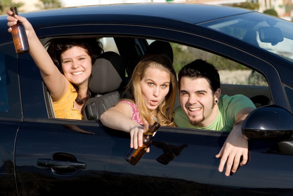 Three teenagers drinking while driving. 