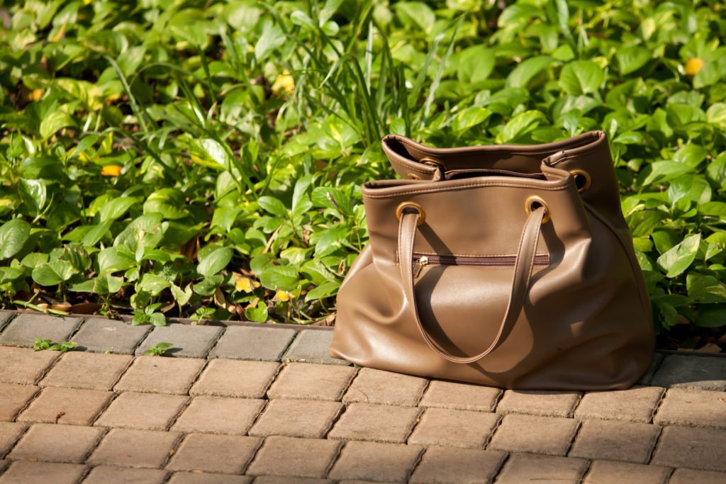 Bolso tirado en el suelo afuera como ejemplo de un engaño de bolso-cebo Bolso tirado en el suelo afuera como ejemplo de un engaño de bolso-cebo