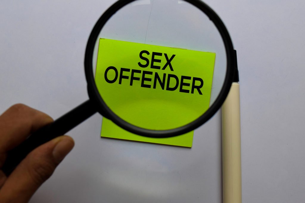 Magnifying glass over sign that says sex offender