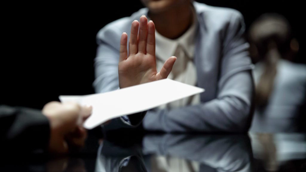 Legislator holding up her hand to refuse a bribe