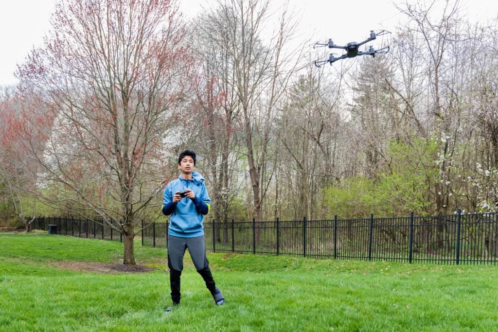 Un chico adolescente volando un drone en el parque