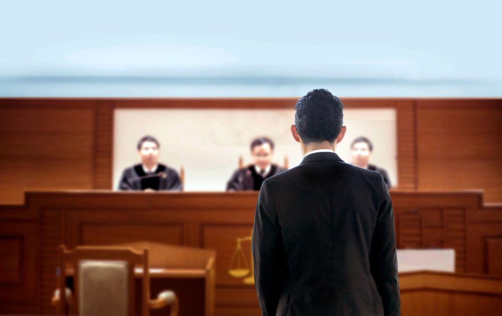 Abogado argumentando un caso de habeas corpus ante un panel judicial