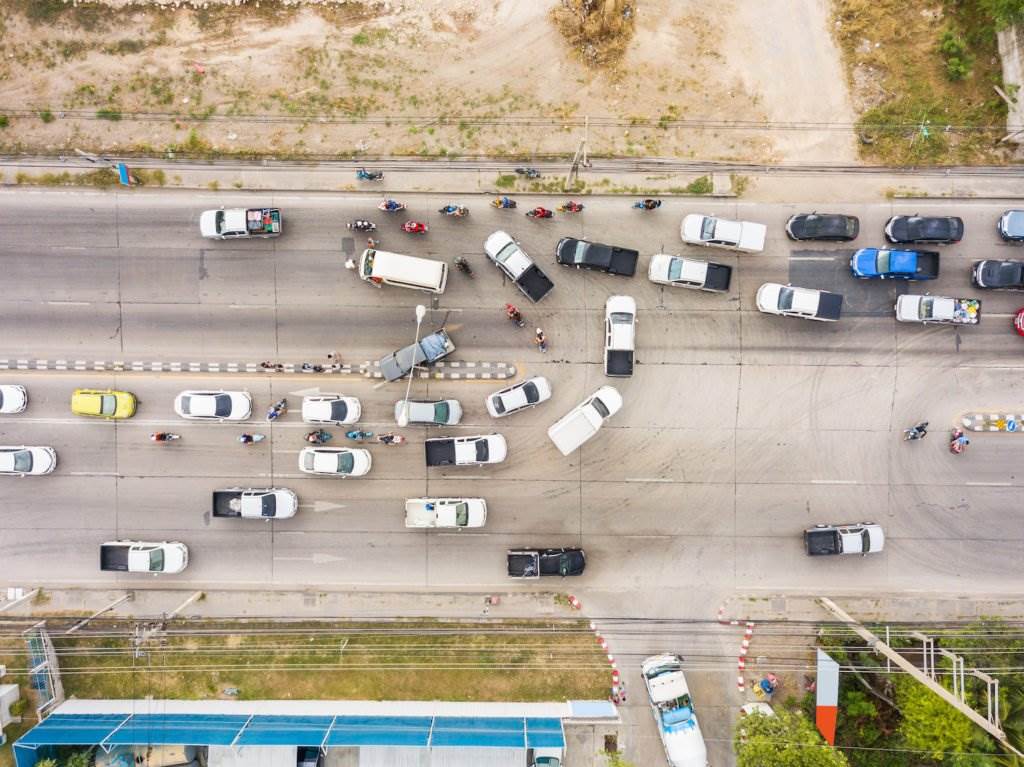 An aerial view of a street with vehicles making u-turns and an apparant accident