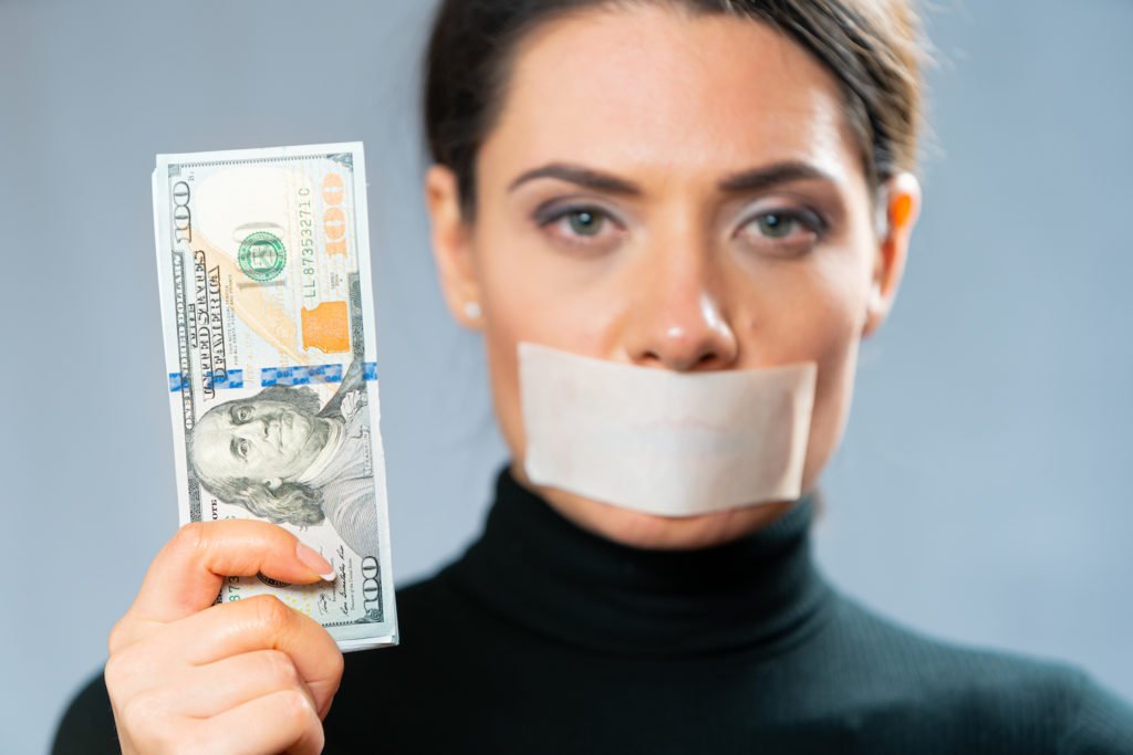 Woman witness with tape over mouth holding cash bribe in violation of PC 138
