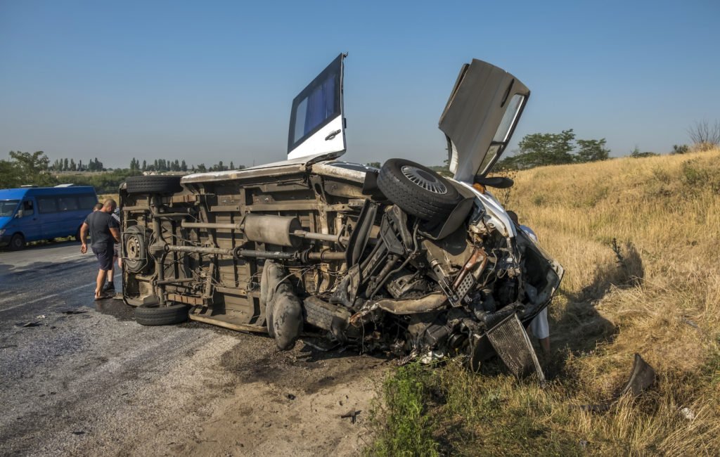 Turned over bus following accident by the side of a road