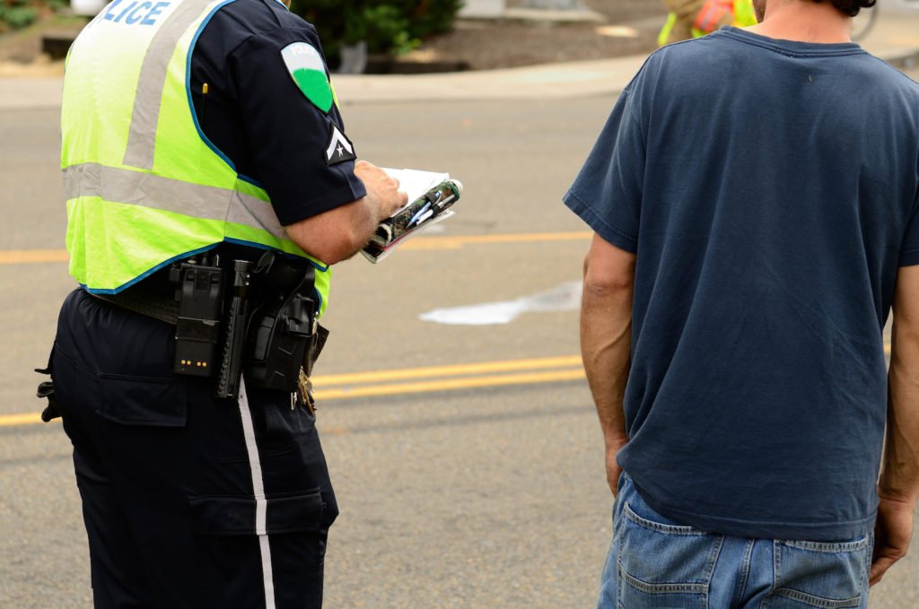 Police writing up a man for breaching the peace in violation of CCC 12.33.010 