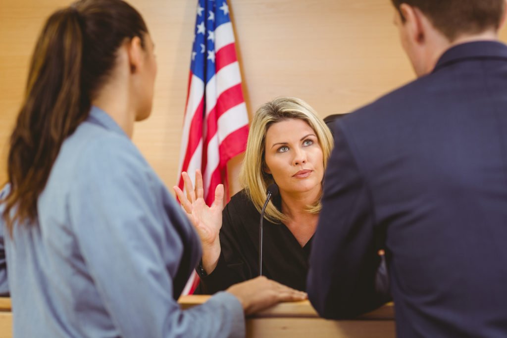 Attorney at bench speaking to two attorneys