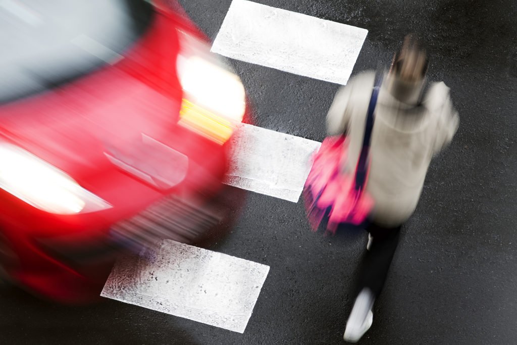 Blurry car trying not to hit pedestrian at crosswalk