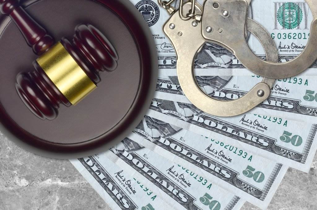 Close-up of gavel, cash, and handcuffs