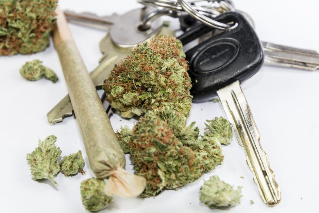 Closeup of marijuana and car keys - driving under the influence of drugs violates CRS 42-4-1301(1)(a).